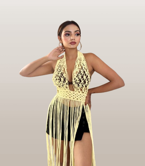 Model wearing a yellow macramé cover-up over a black swimsuit on a plain background 